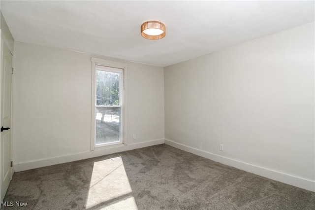 empty room featuring carpet flooring and baseboards