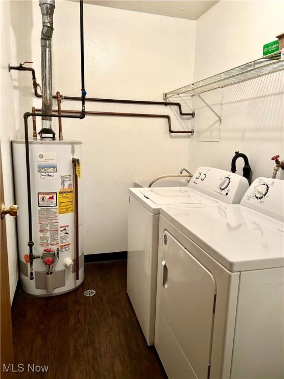 washroom with washer and dryer, dark wood-type flooring, water heater, and laundry area