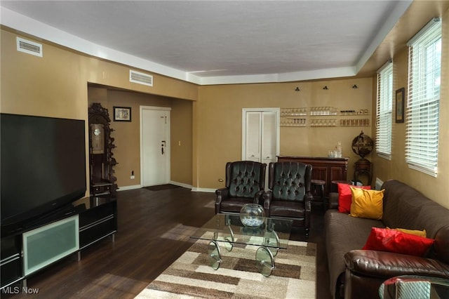 living room with visible vents, baseboards, and wood finished floors