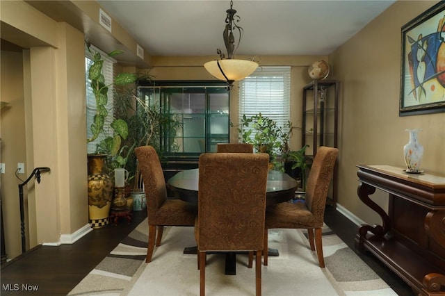 dining room featuring visible vents, baseboards, and wood finished floors