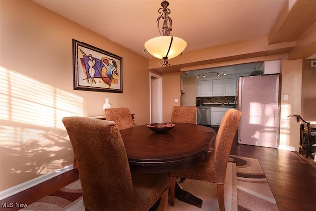 dining room with baseboards and dark wood-type flooring