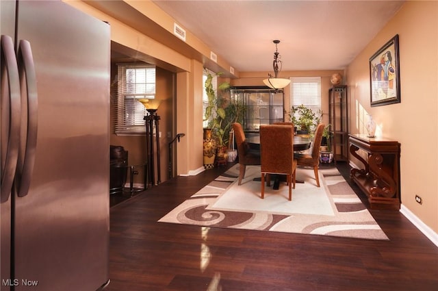 dining area featuring baseboards, a healthy amount of sunlight, and wood finished floors