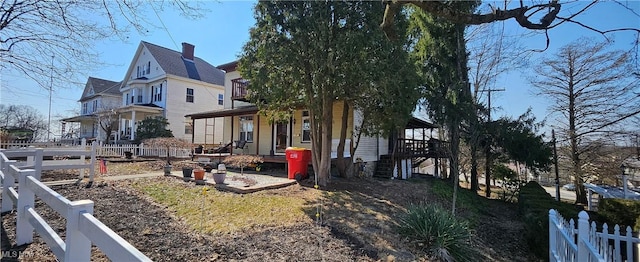 view of home's exterior with a balcony, a porch, and fence private yard