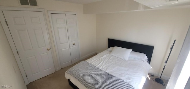 carpeted bedroom with a closet and visible vents