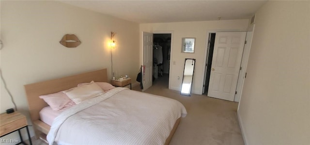 bedroom featuring a spacious closet, baseboards, a closet, and carpet floors