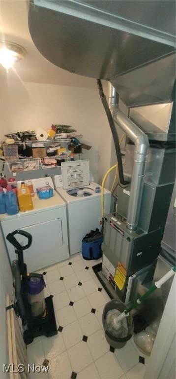 interior space featuring laundry area, tile patterned floors, and washing machine and clothes dryer