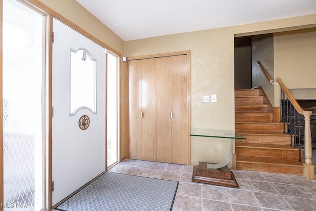 foyer entrance featuring stairway and tile patterned flooring