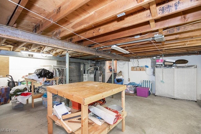 unfinished basement featuring visible vents and water heater