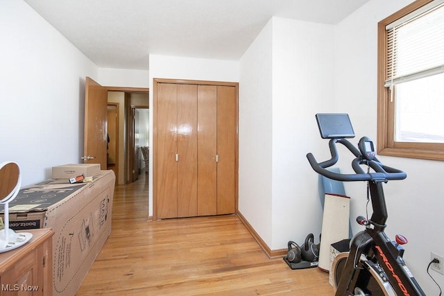 workout area with light wood-style flooring and baseboards