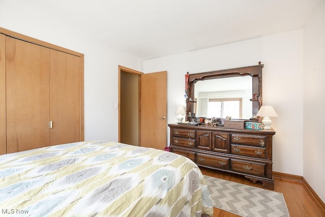 bedroom featuring a closet, baseboards, and wood finished floors