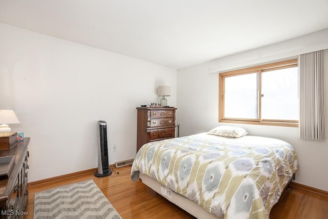 bedroom featuring visible vents, baseboards, and light wood-style flooring