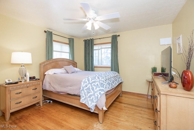 bedroom with baseboards, a ceiling fan, and light wood finished floors