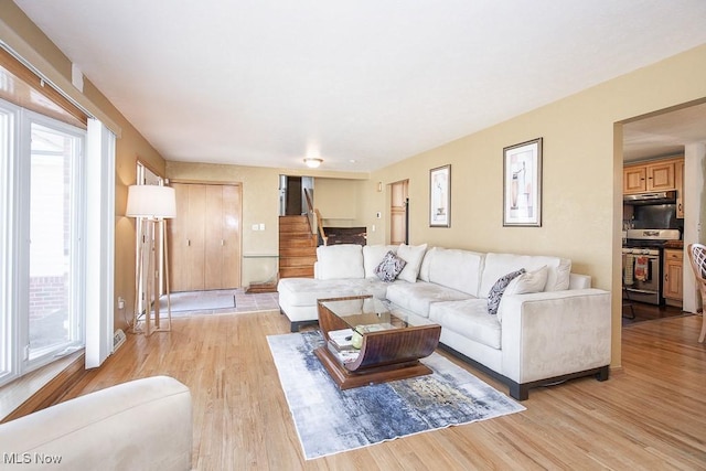 living area featuring stairway and light wood-type flooring