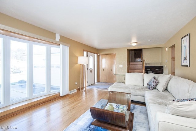 living area with light wood-style flooring and visible vents