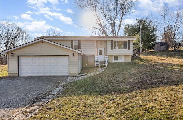 split foyer home with a shed, an attached garage, driveway, and a front lawn