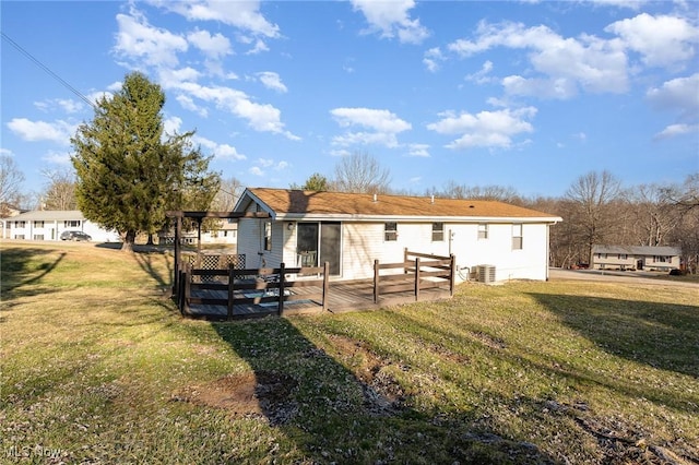 back of property with central air condition unit and a lawn