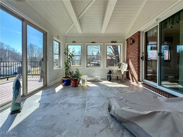 unfurnished sunroom with lofted ceiling with beams, wood ceiling, and a wealth of natural light