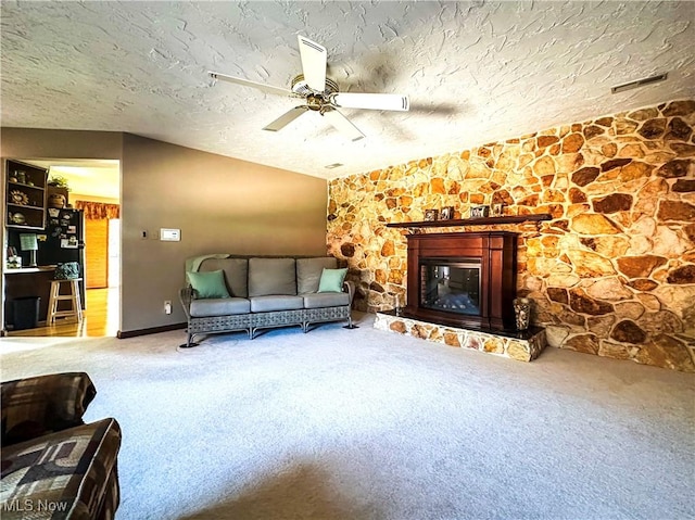 unfurnished living room with a ceiling fan, a textured ceiling, a fireplace, carpet flooring, and vaulted ceiling