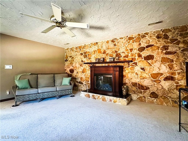 unfurnished living room with a ceiling fan, a textured ceiling, a fireplace, carpet flooring, and vaulted ceiling