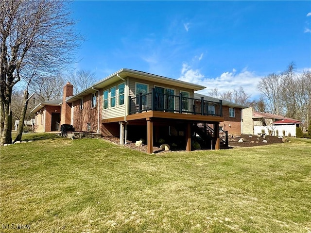 rear view of house with brick siding, stairway, a wooden deck, a lawn, and a chimney