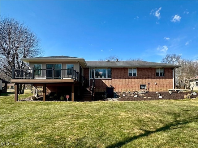 rear view of house with stairway, a yard, a deck, and brick siding