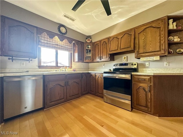 kitchen with light wood finished floors, visible vents, light countertops, appliances with stainless steel finishes, and a sink