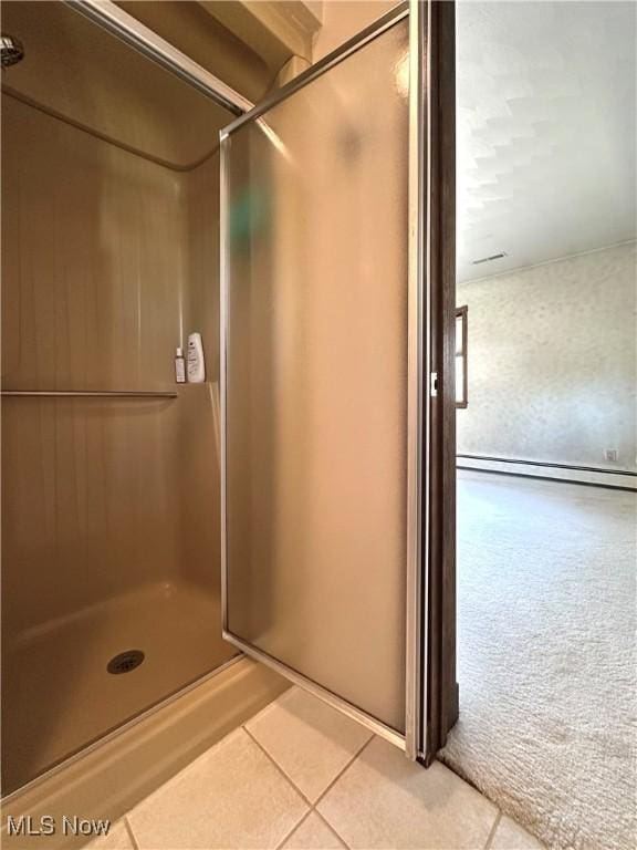 full bathroom with a stall shower and tile patterned flooring