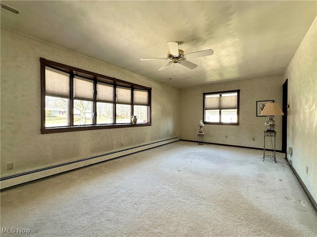 carpeted empty room with a baseboard heating unit, a ceiling fan, and visible vents