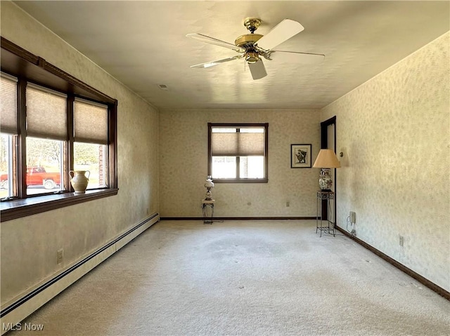 carpeted spare room featuring baseboards, wallpapered walls, ceiling fan, and a baseboard radiator