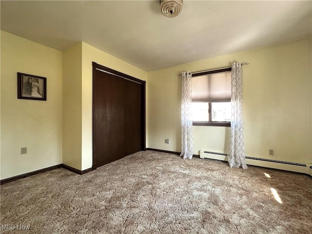 unfurnished bedroom with baseboards, carpet floors, baseboard heating, and a closet