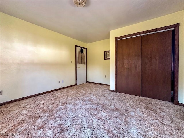 unfurnished bedroom with a closet, visible vents, baseboards, and carpet floors