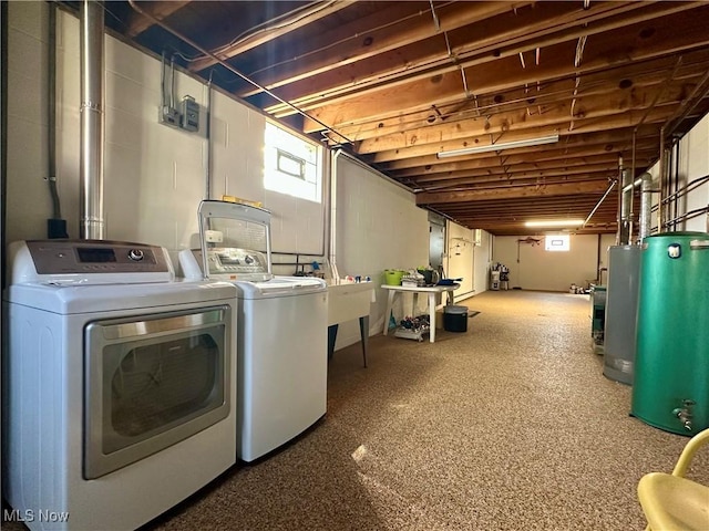 washroom featuring laundry area, water heater, and washer and clothes dryer