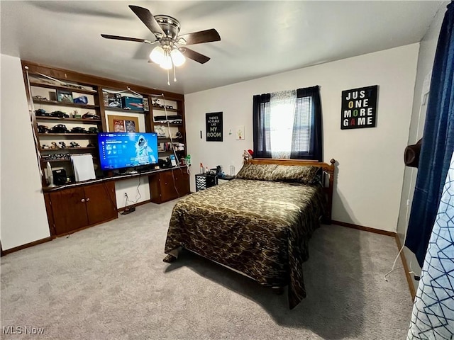 bedroom featuring carpet flooring, a ceiling fan, baseboards, and built in study area