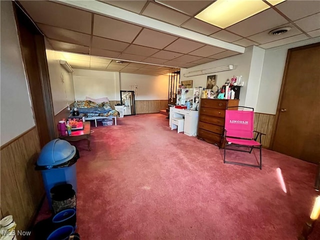 finished basement with a wainscoted wall, wood walls, and carpet