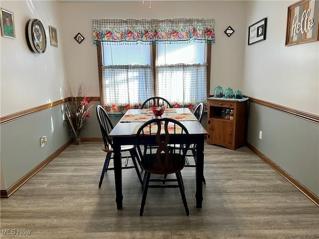 dining space with wood finished floors and baseboards