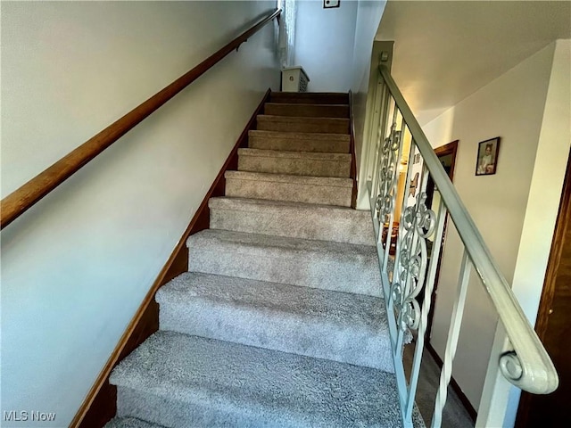 staircase featuring baseboards