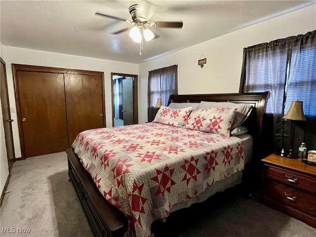 carpeted bedroom with a closet, multiple windows, and a ceiling fan