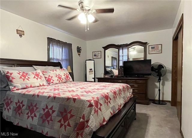 bedroom with a ceiling fan, multiple windows, and light colored carpet