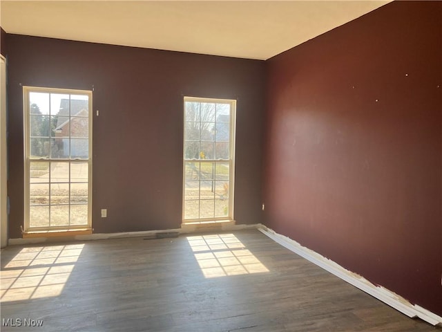 empty room with baseboards and wood finished floors