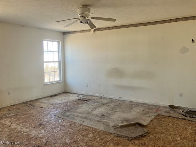 empty room with baseboards and ceiling fan