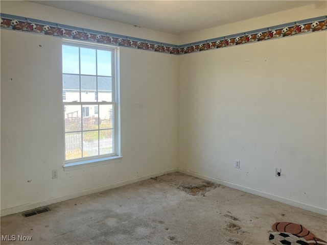 carpeted spare room featuring baseboards and visible vents