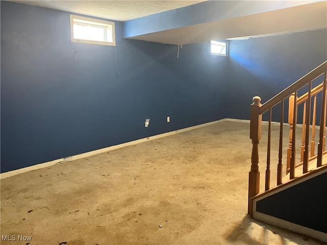 below grade area with stairs and baseboards