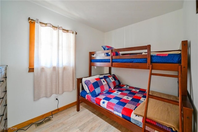 bedroom with wood finished floors, visible vents, and baseboards