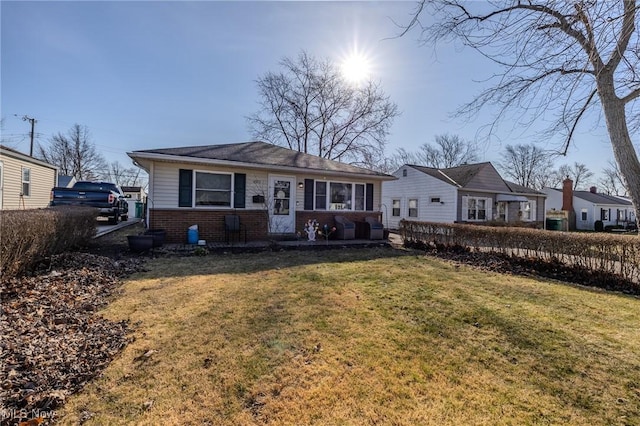 view of front of home with a front yard and brick siding