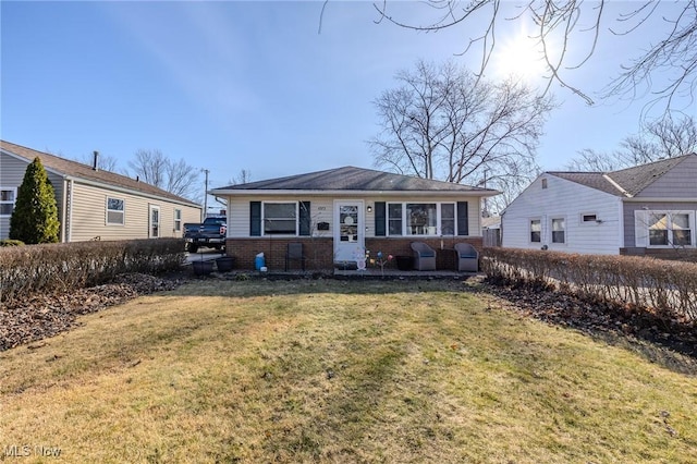 rear view of property featuring a lawn and brick siding