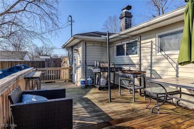 wooden terrace featuring a grill and fence