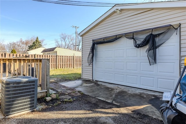 garage featuring cooling unit and fence