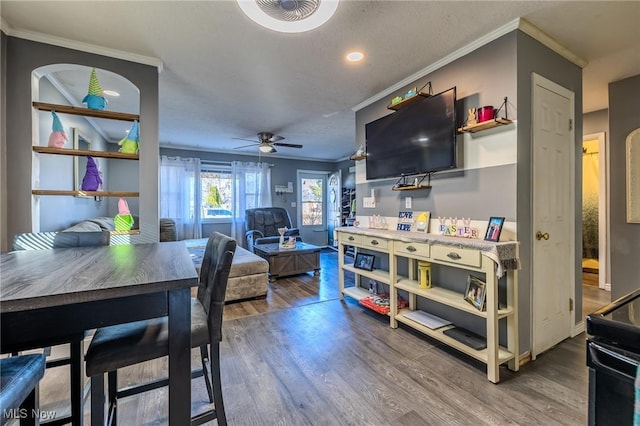 dining area featuring ceiling fan, wood finished floors, and ornamental molding