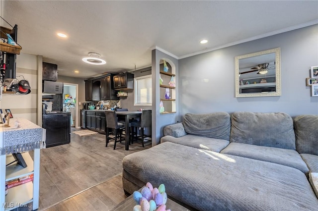 living room featuring light wood finished floors, recessed lighting, and crown molding