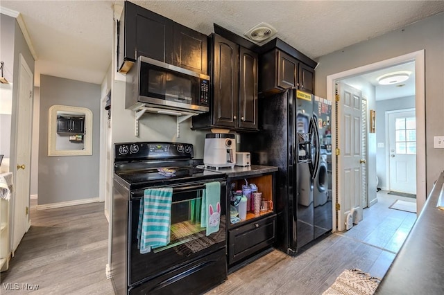 kitchen with visible vents, baseboards, black appliances, and light wood finished floors